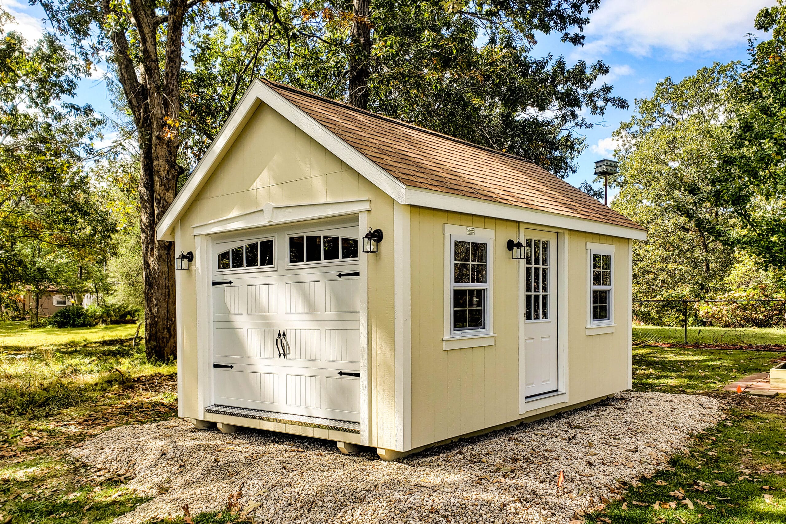 One of our navy blue storage buildings for sale in Sullivan MO - Blue siding with white overhead and side door and white -framed window and dark metal roof