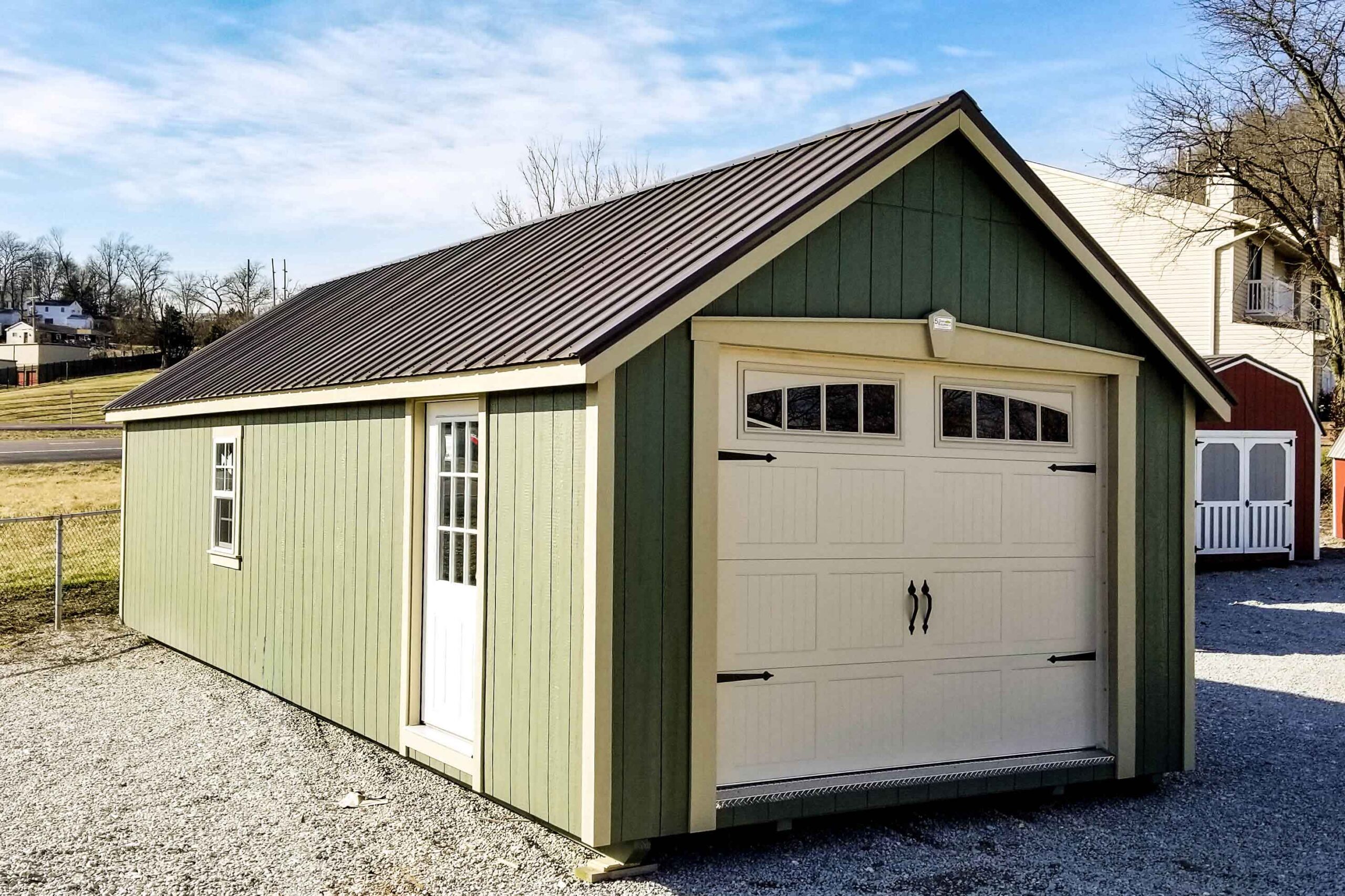 One of our navy blue storage buildings for sale in Sullivan MO - Blue siding with white overhead and side door and white -framed window and dark metal roof