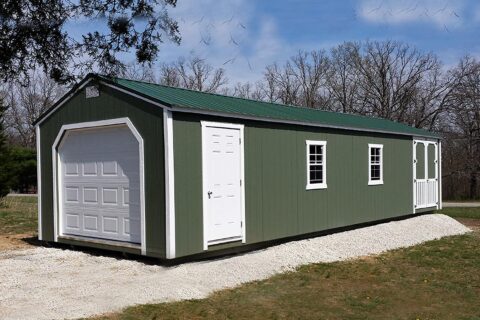 Green portable garage in MO with green wooden siding and an overhead garage door